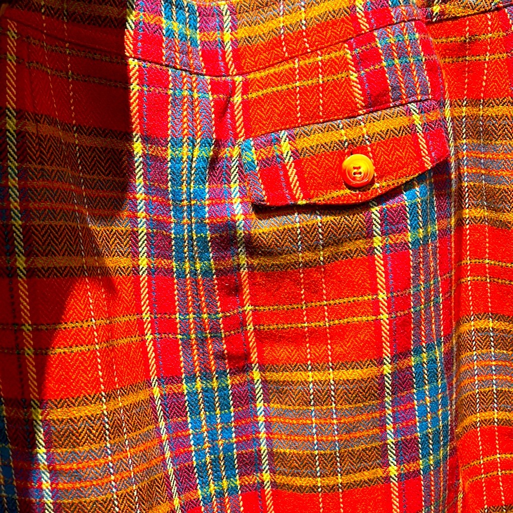 Multi color stripe wrapped skirt with front zipper and button closure.